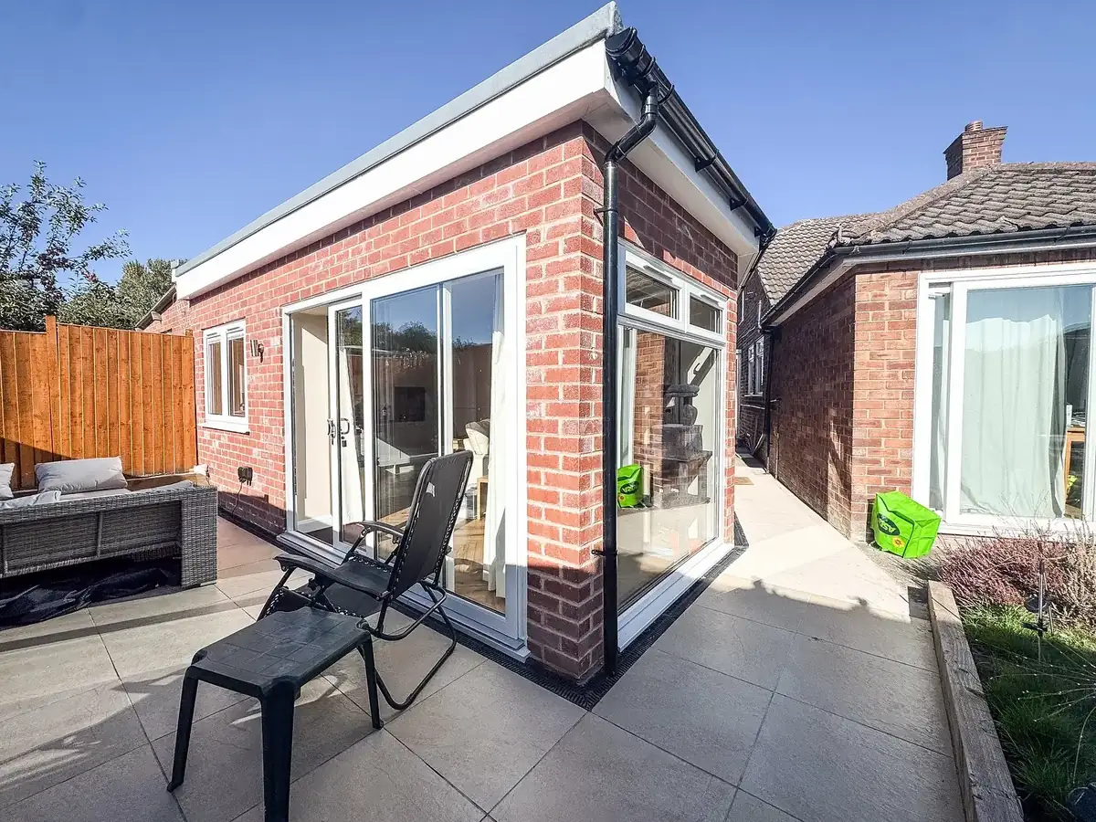 Finished single-storey brick extension with patio doors onto a paved terrace
