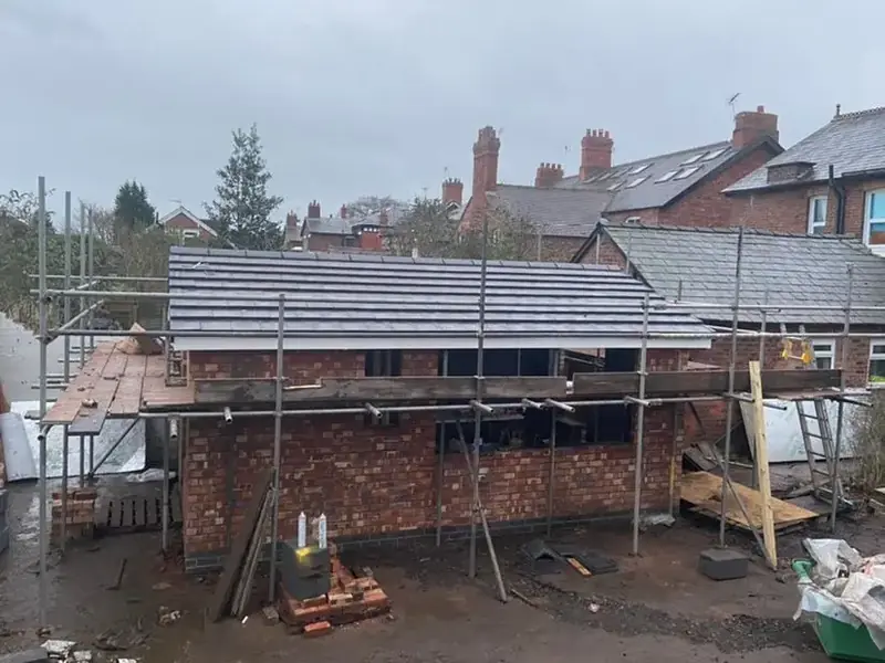 Single-storey building under construction with scaffolding and a newly tiled roof