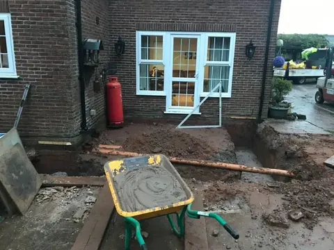 Rear elevation with new French doors fitted while groundworks continue outside
