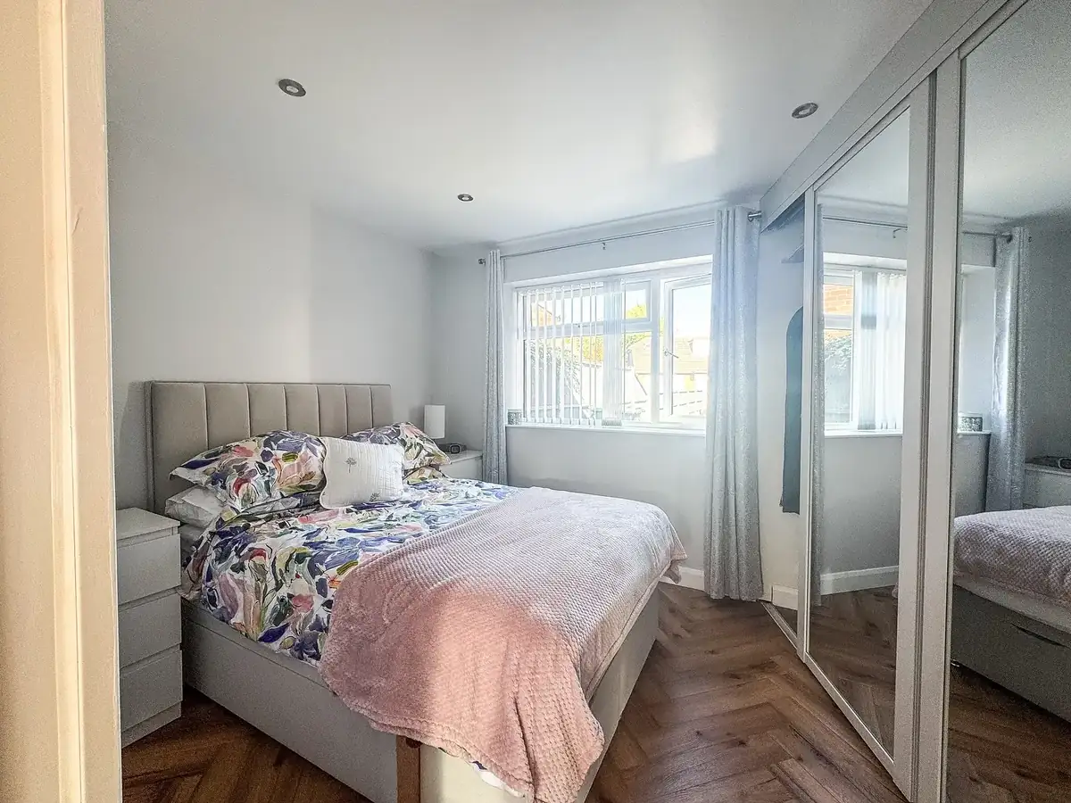 Finished bedroom with mirrored wardrobes and a large replacement window