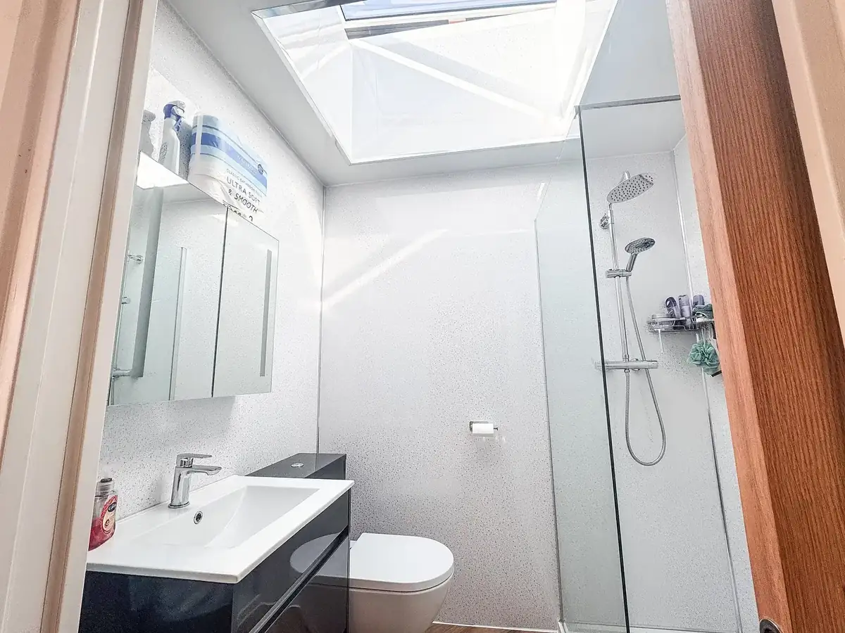 Finished bathroom with a walk-in shower and a rooflight above the basin