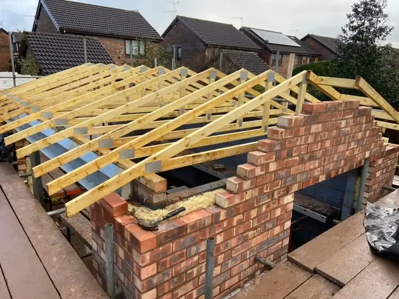 New timber roof trusses craned into position on fresh brickwork