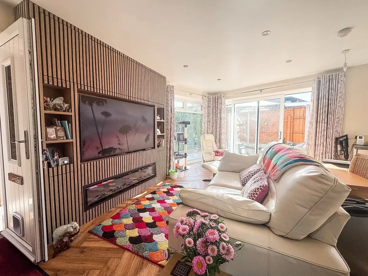 Open-plan living room with a panelled feature wall after a full renovation