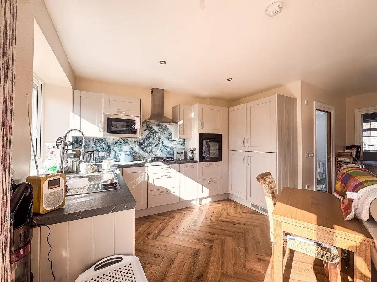 Completed kitchen with smooth plastered walls and parquet flooring